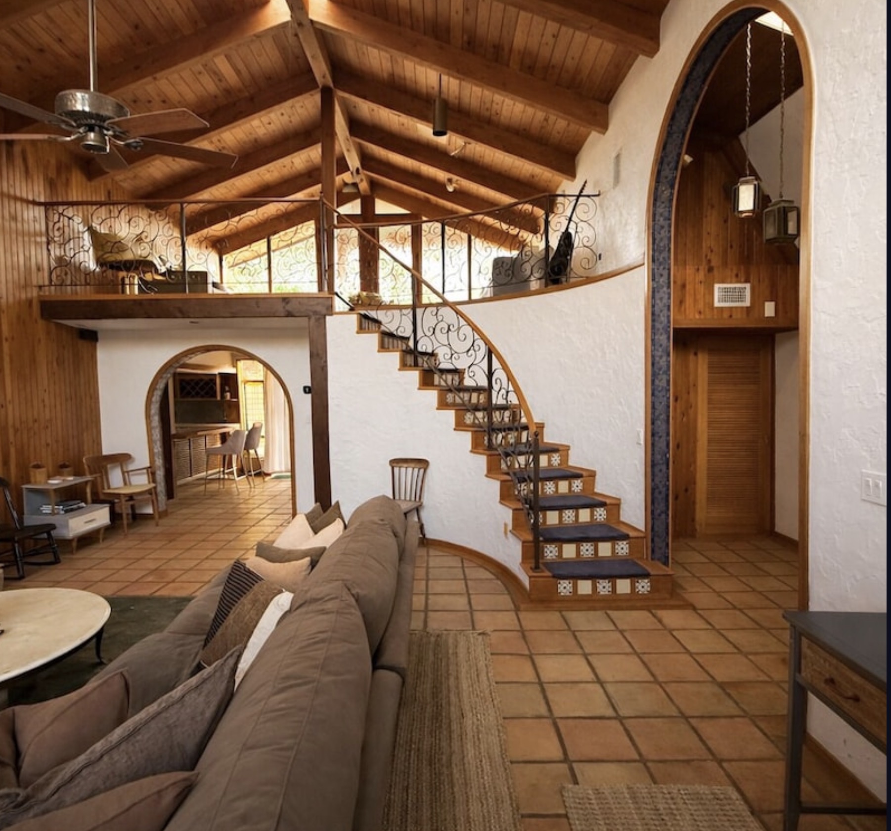 Great Room — Cathedral ceilings with wrought-iron spiral staircase to loft